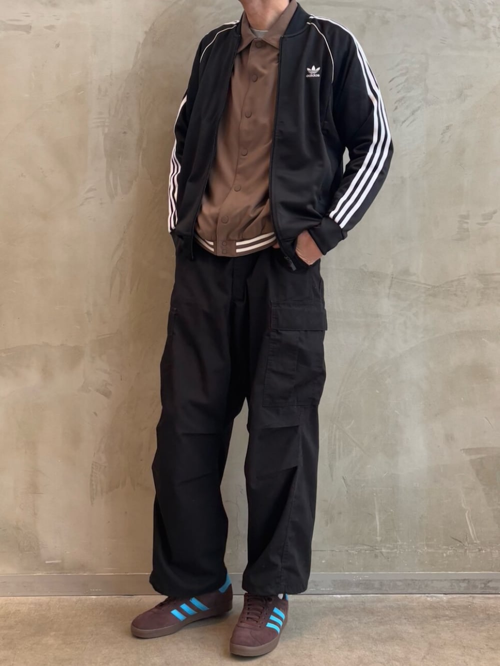 ブラウン系のジャケット/アウター、ブラウン系のスニーカー、ブラック系のジャージを着用したメンズの冬コーディネートの2枚目の写真