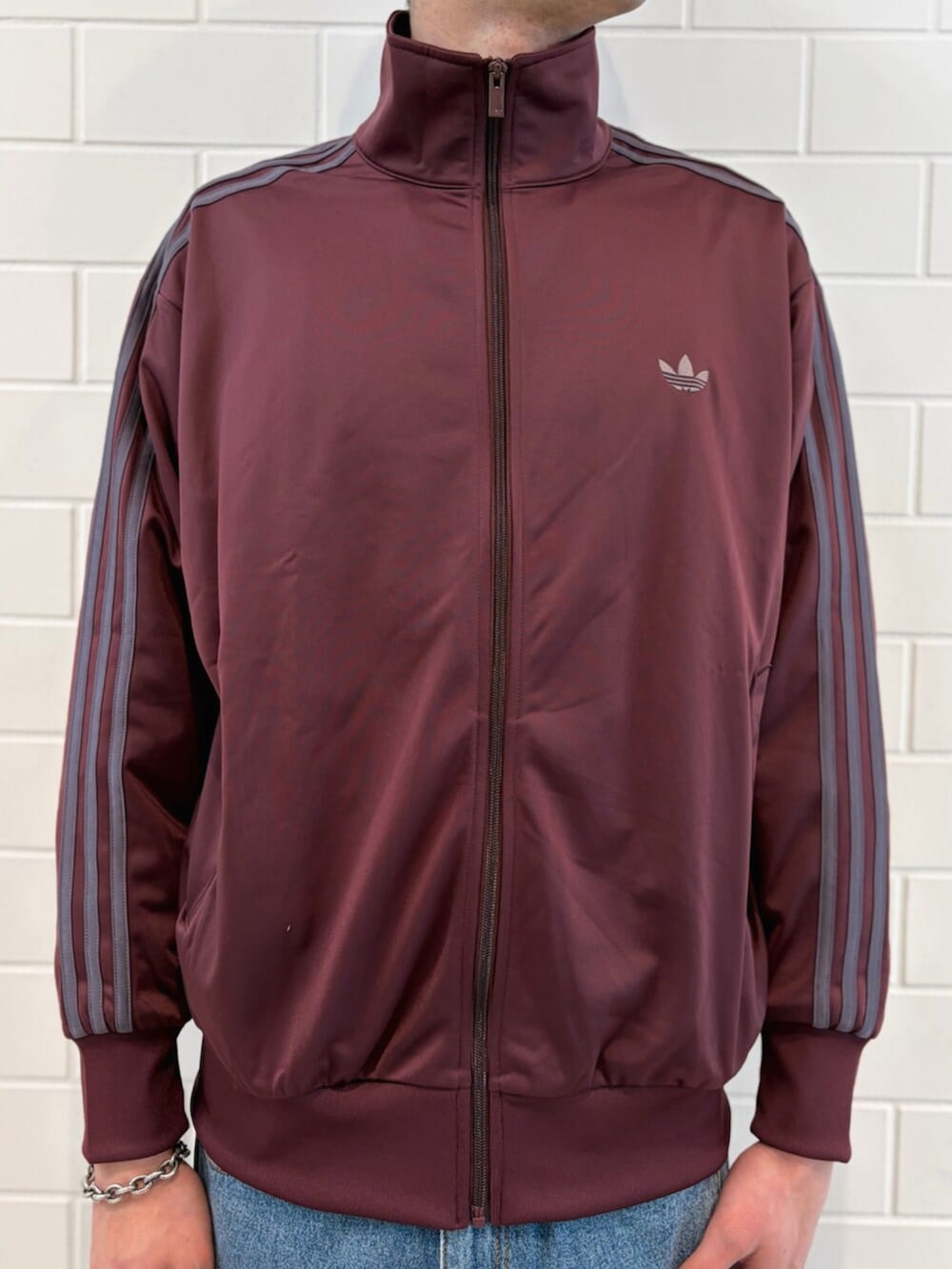 ブラウン系のスニーカー、ブルー系のデニムパンツ、レッド系のジャージを着用したメンズの春コーディネートの4枚目の写真