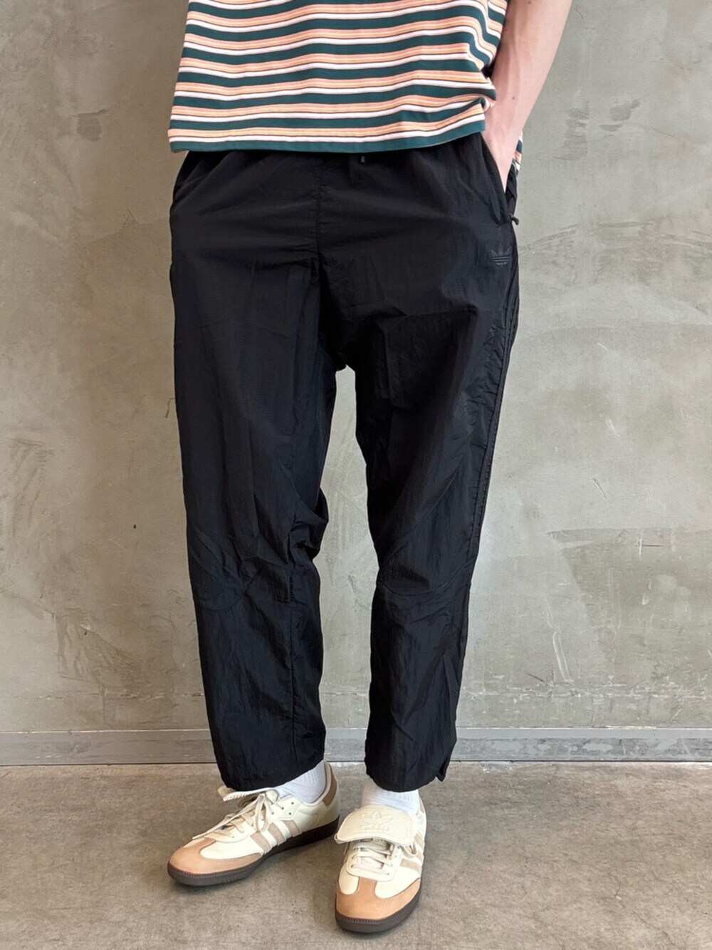 ホワイト系のスニーカー、ブラウン系のナイロンジャケット、ブラック系のその他パンツを着用したメンズの春コーディネートの5枚目の写真