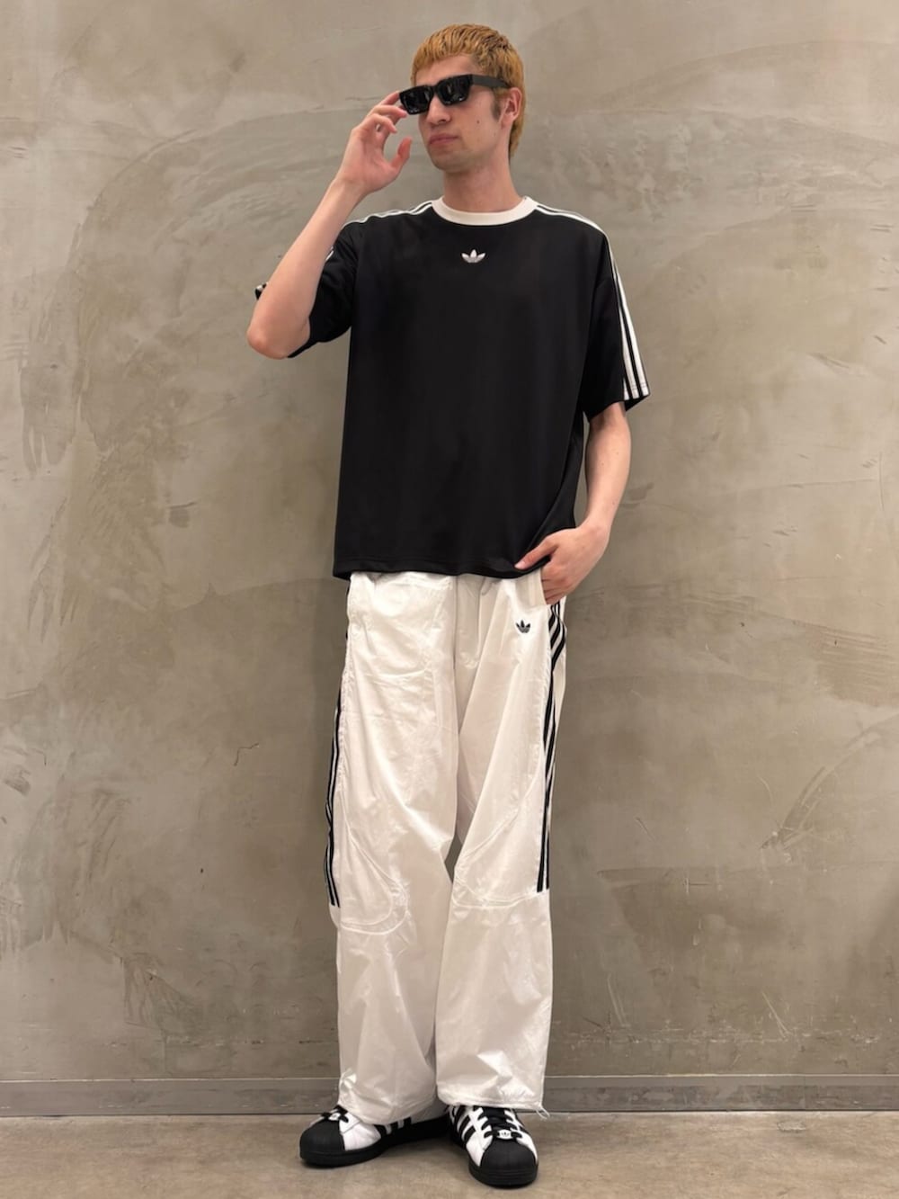 ホワイト系のスニーカー、ブラック系のTシャツ/カットソー、ホワイト系のその他パンツを着用したメンズの夏コーディネートの3枚目の写真