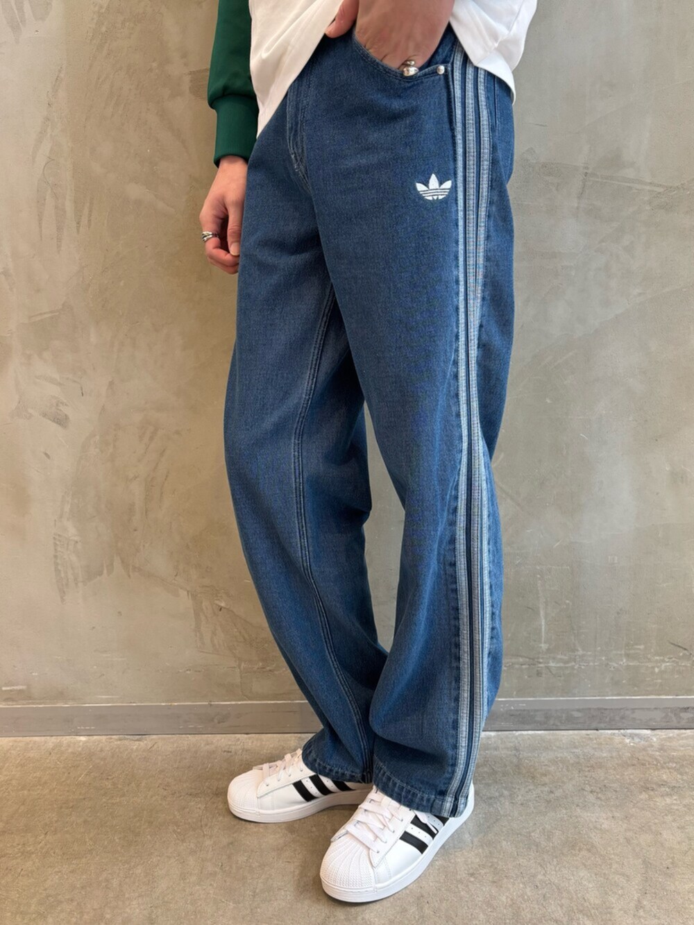 グリーン系のナイロンジャケット、ブルー系のデニムパンツ、ホワイト系のTシャツ/カットソーを着用したメンズの春コーディネートの5枚目の写真