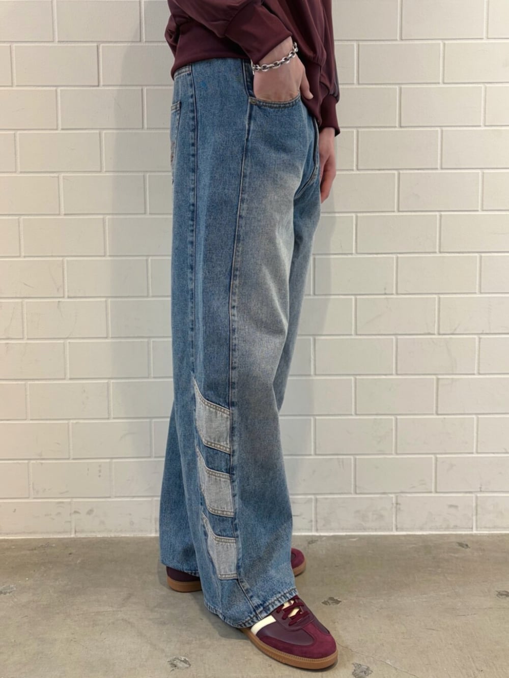 ブラウン系のスニーカー、ブルー系のデニムパンツ、レッド系のジャージを着用したメンズの春コーディネートの5枚目の写真