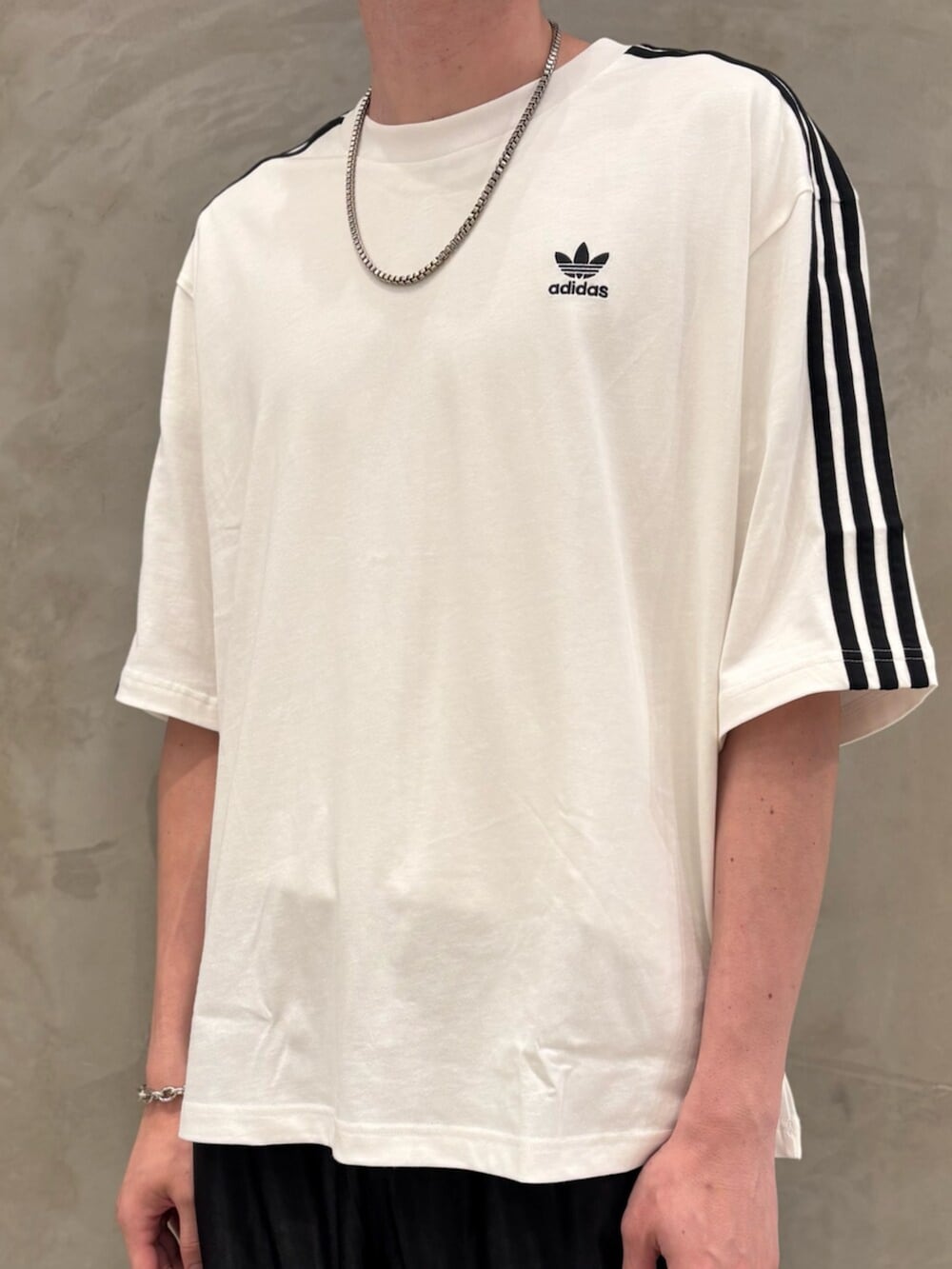 ホワイト系のTシャツ/カットソー、ブラック系のスニーカー、ブラック系のスウェットパンツを着用したメンズの夏コーディネートの4枚目の写真