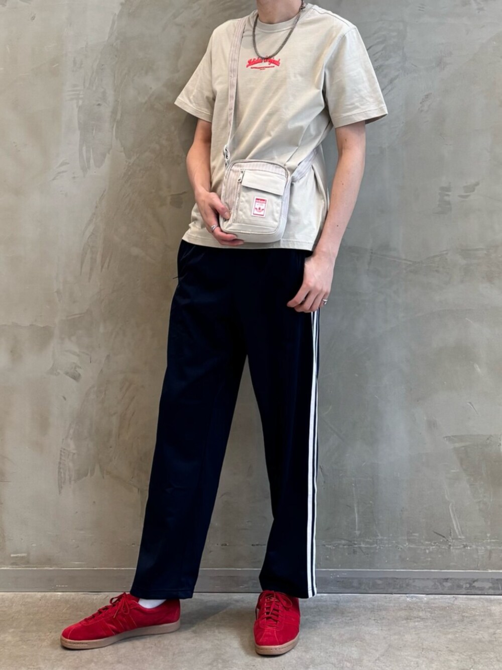 ブルー系のスウェットパンツ、ベージュ系のTシャツ/カットソー、レッド系のスニーカーを着用したメンズの春コーディネートの2枚目の写真