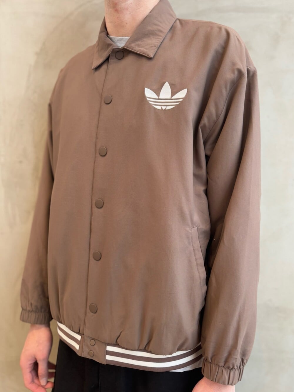 ブラウン系のジャケット/アウター、ブラウン系のスニーカー、ブラック系のジャージを着用したメンズの冬コーディネートの5枚目の写真