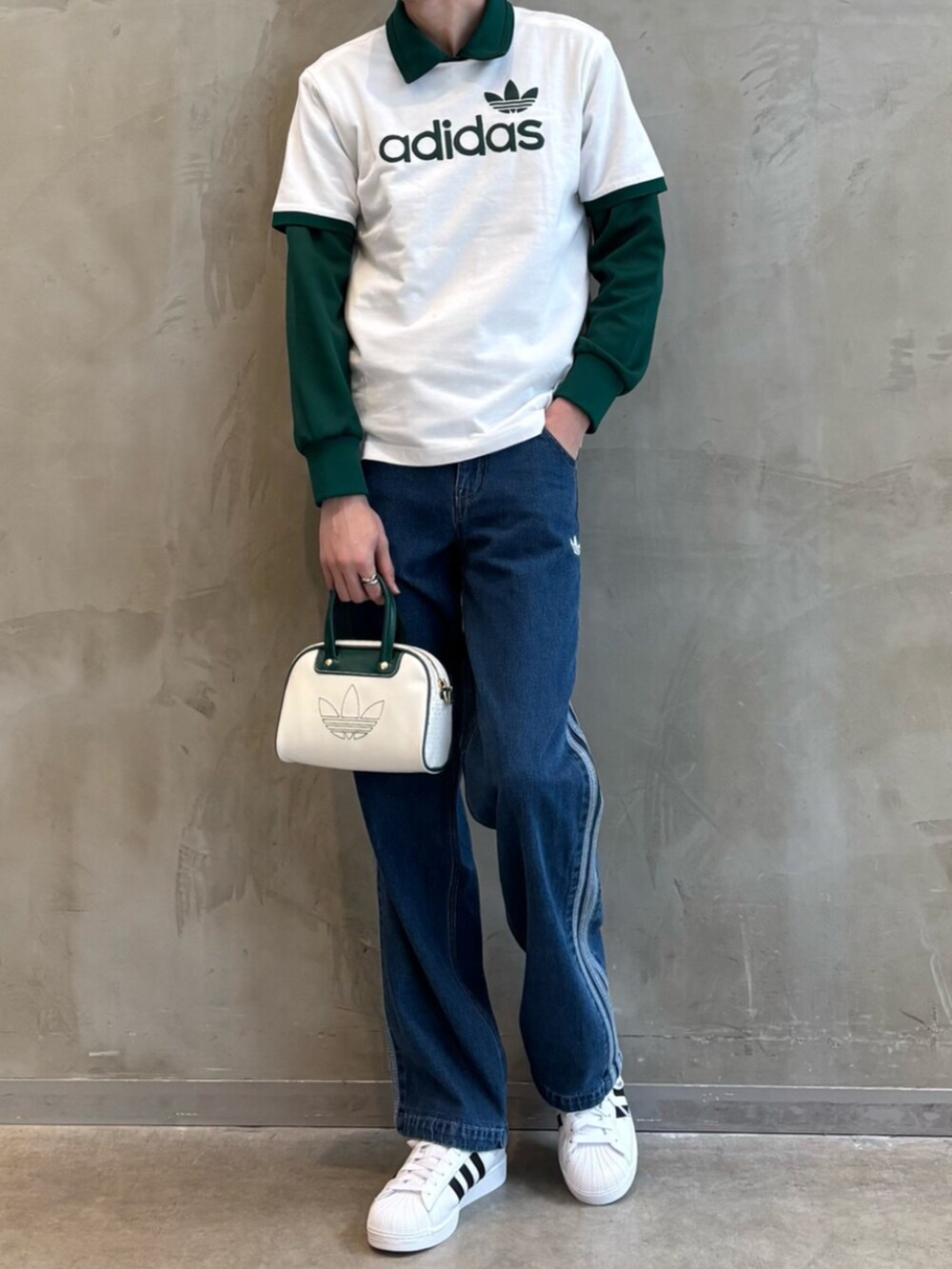 グリーン系のナイロンジャケット、ブルー系のデニムパンツ、ホワイト系のTシャツ/カットソーを着用したメンズの春コーディネートの2枚目の写真