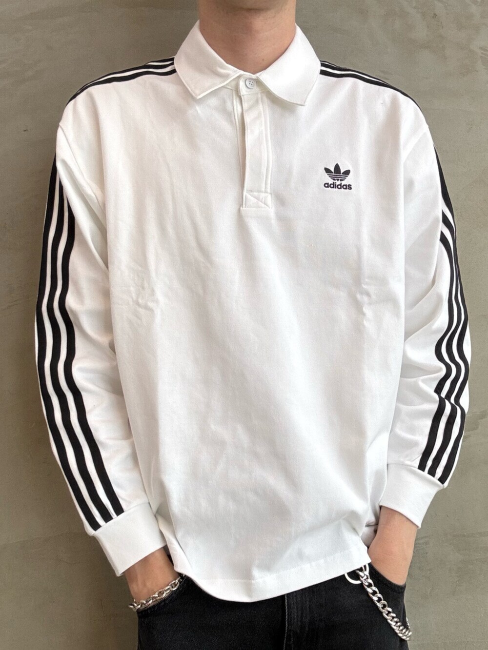 ホワイト系のポロシャツ、ブラック系のTシャツ/カットソー、ホワイト系のスニーカーを着用したメンズの夏コーディネートの5枚目の写真