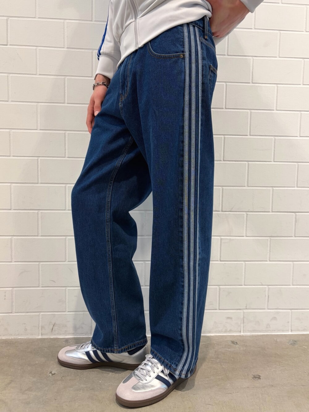 ブルー系のデニムパンツ、グレー系のトップス、シルバー系のスニーカーを着用したメンズの春コーディネートの5枚目の写真