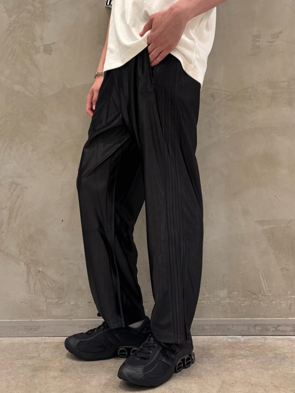 ホワイト系のTシャツ/カットソー、ブラック系のスニーカー、ブラック系のスウェットパンツを着用したメンズの夏コーディネートの5枚目の写真