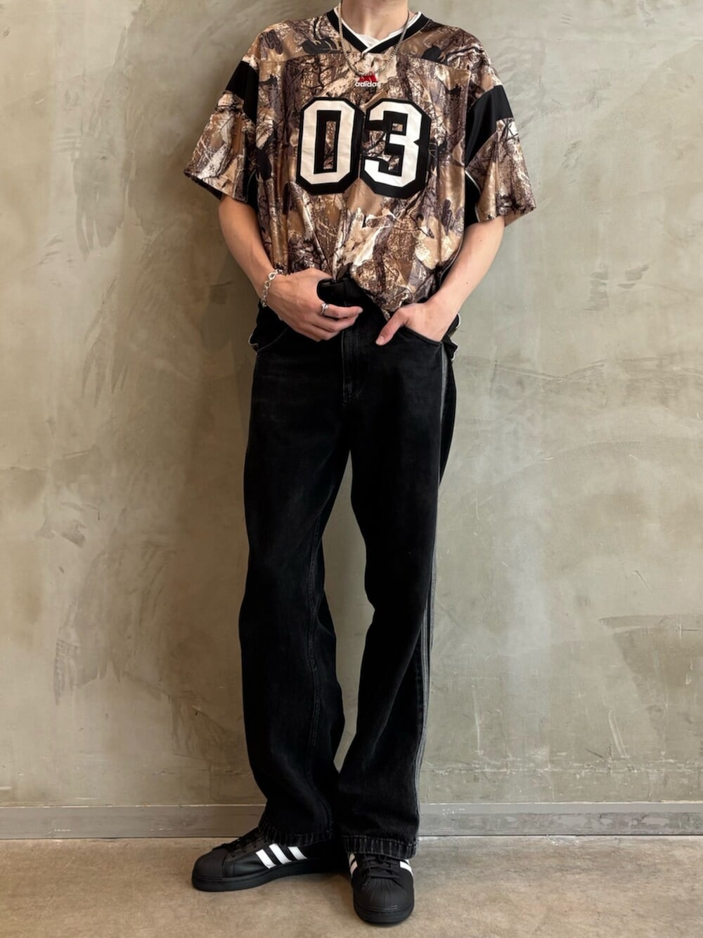 ブラック系のデニムパンツ、その他のTシャツ/カットソー、ブラック系のスニーカーを着用したメンズの夏コーディネートの2枚目の写真
