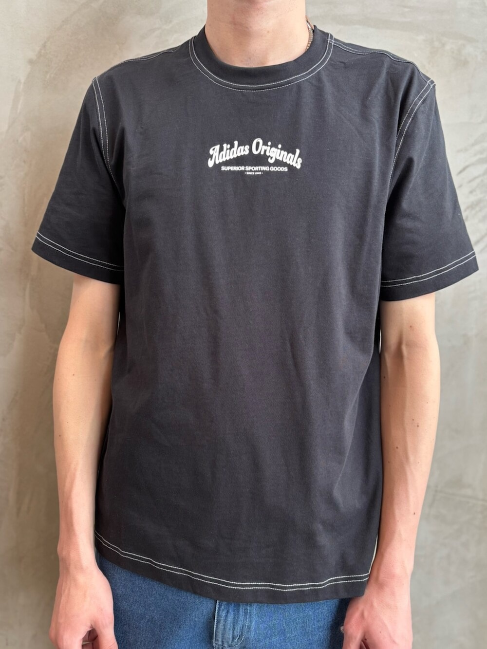 ブルー系のデニムパンツ、グリーン系のスニーカー、ブラック系のTシャツ/カットソーを着用したメンズの春コーディネートの4枚目の写真