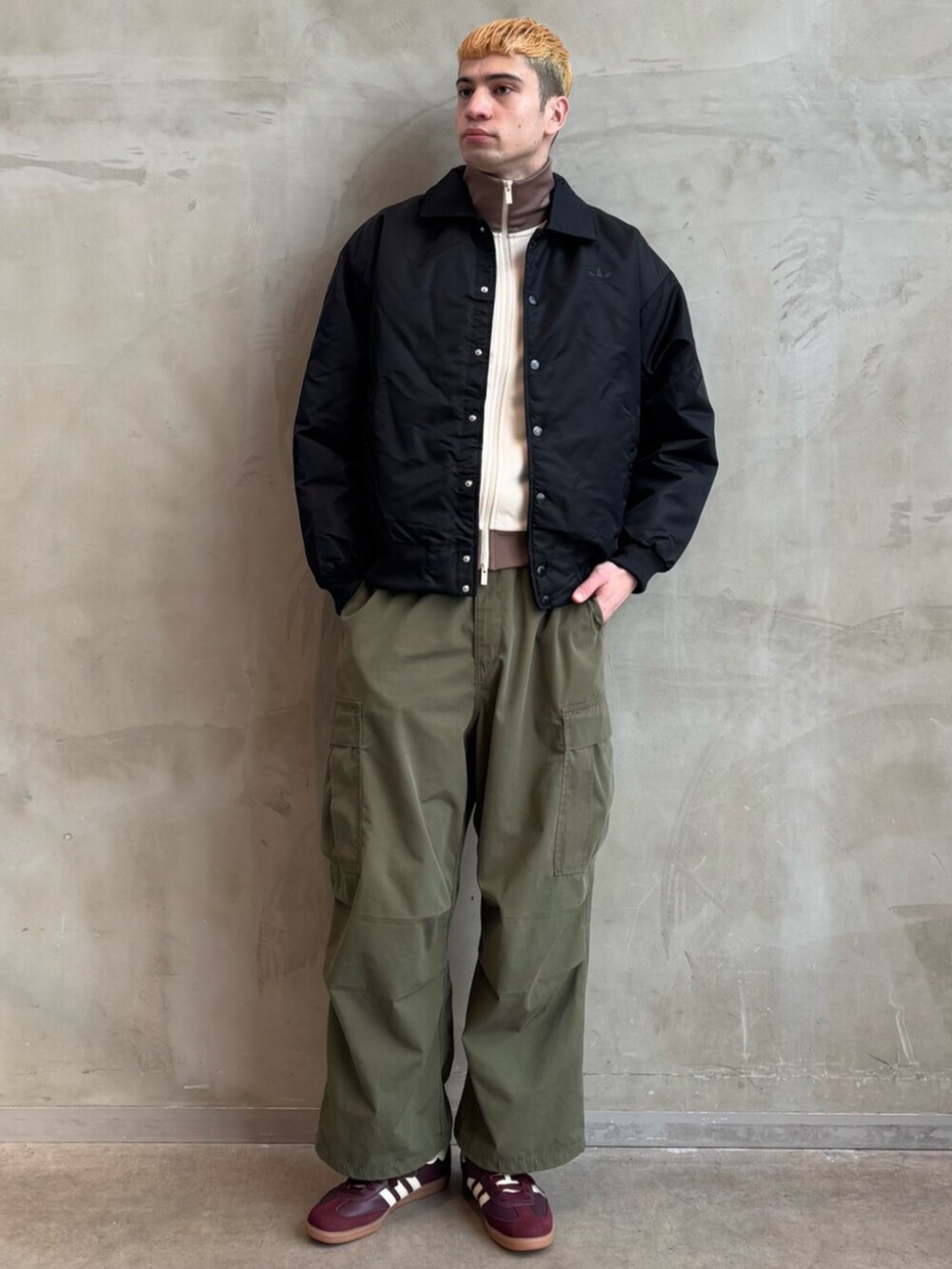 ブラック系のブルゾン、レッド系のスニーカー、ホワイト系のトップスを着用したメンズの春コーディネートの3枚目の写真