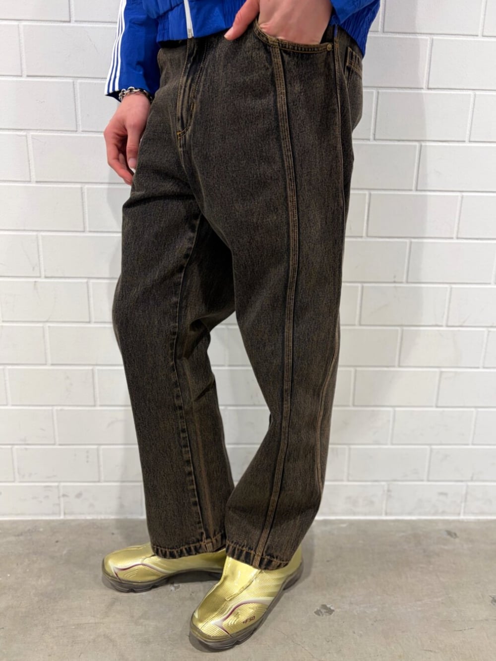 ゴールド系のシューズ、ブルー系のナイロンジャケット、ブラウン系のデニムパンツを着用したメンズの春コーディネートの5枚目の写真