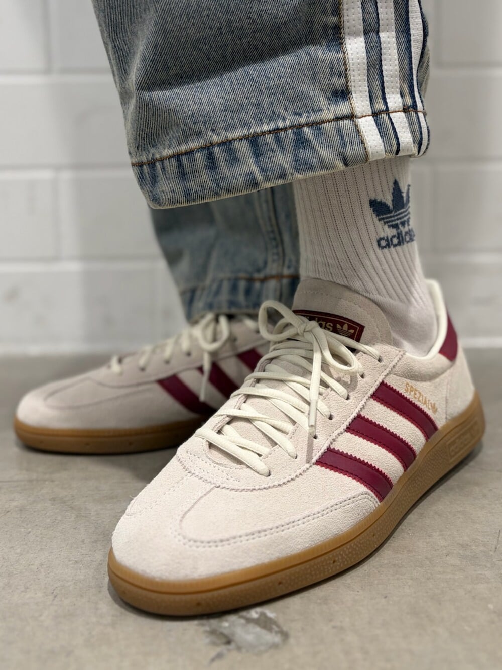 ブルー系のデニムパンツ、ホワイト系のトップス、ホワイト系のシューズを着用したメンズの春コーディネートの6枚目の写真