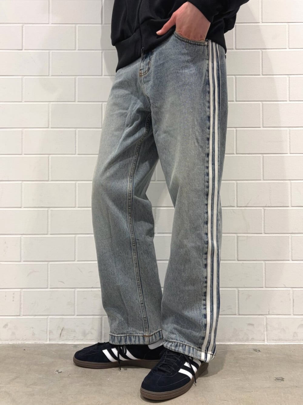 ブラック系のジャージ、ブラック系のスニーカー、ブルー系のデニムパンツを着用したメンズの春コーディネートの5枚目の写真