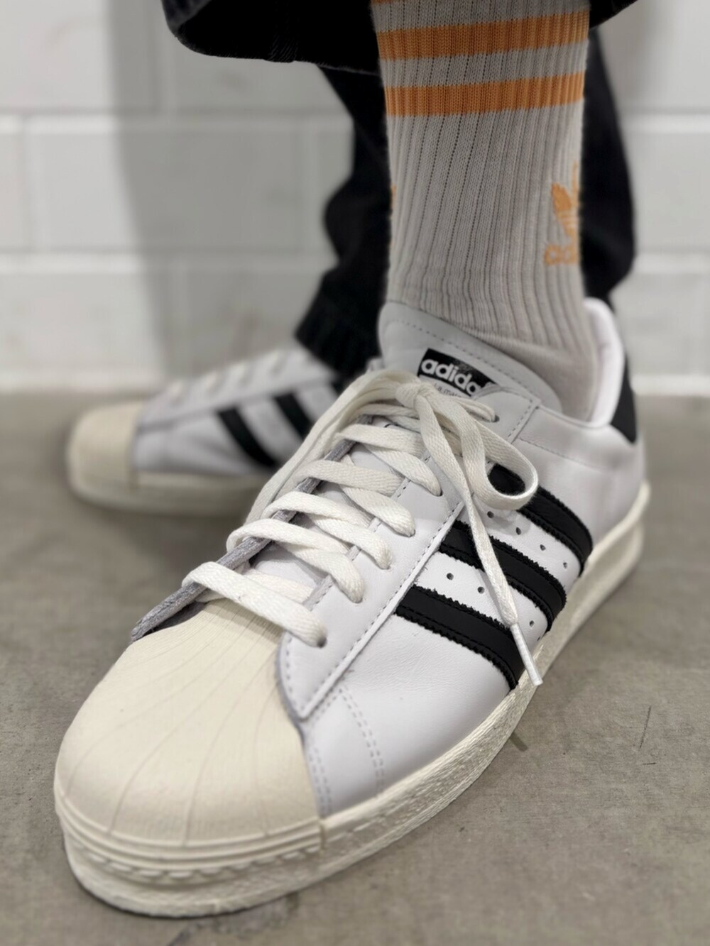 ブラック系のデニムパンツ、ホワイト系のシューズ、ブラック系のジャージを着用したメンズの秋コーディネートの6枚目の写真