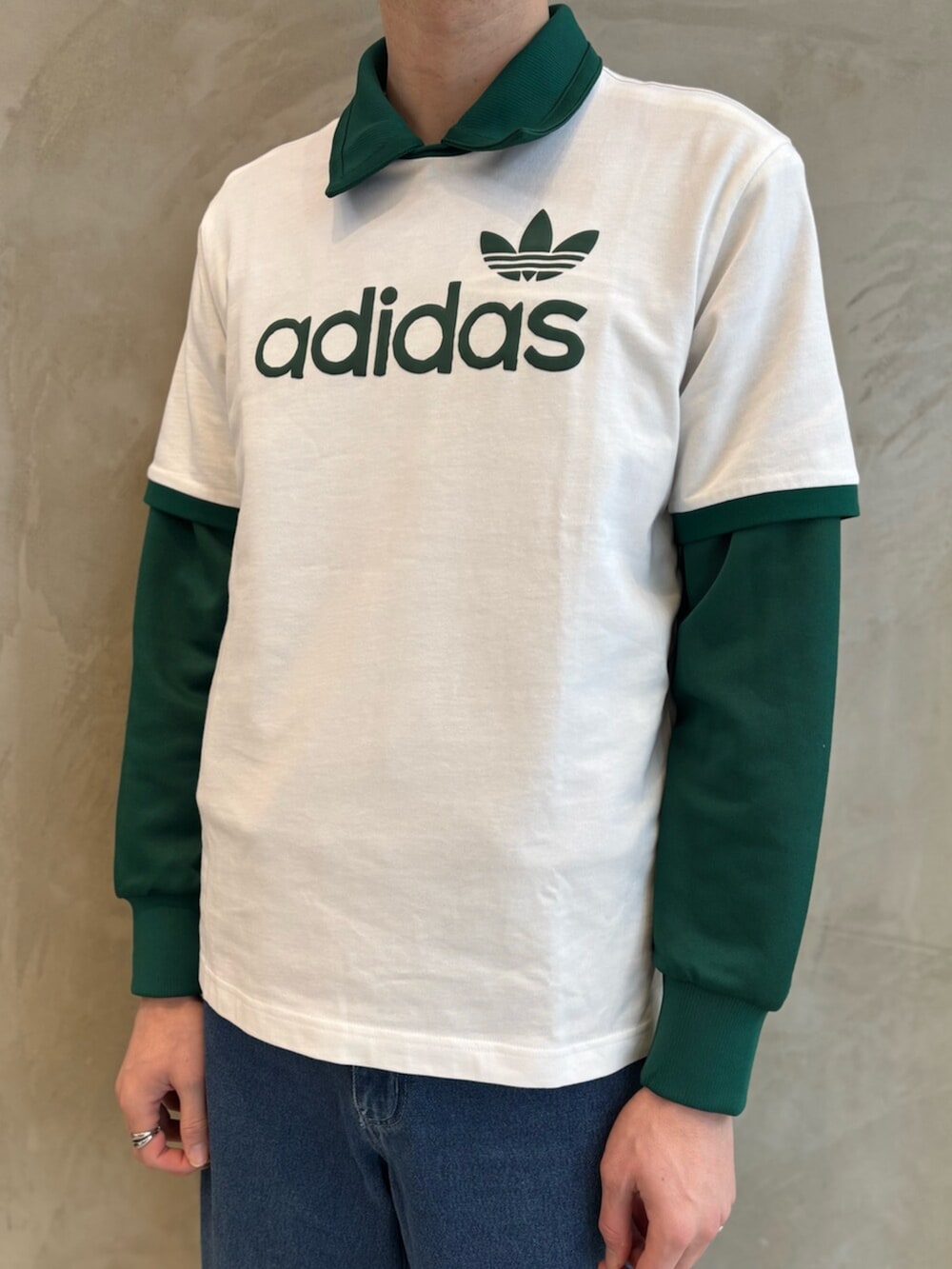 グリーン系のナイロンジャケット、ブルー系のデニムパンツ、ホワイト系のTシャツ/カットソーを着用したメンズの春コーディネートの4枚目の写真