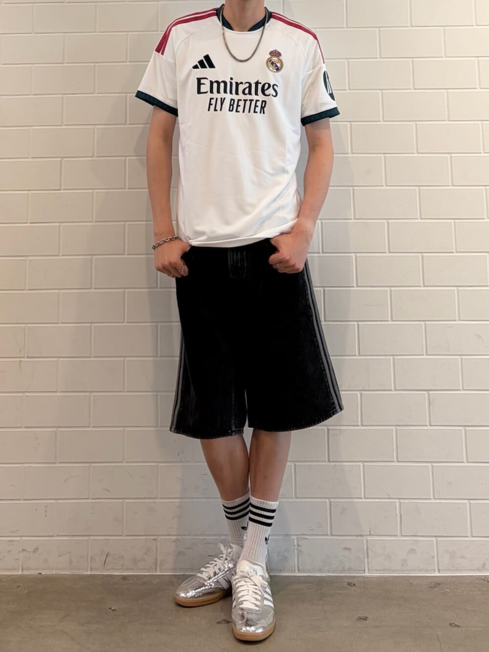 シルバー系のスニーカー、ブラック系のデニムパンツ、ホワイト系のTシャツ/カットソーを着用したメンズの夏コーディネートの2枚目の写真