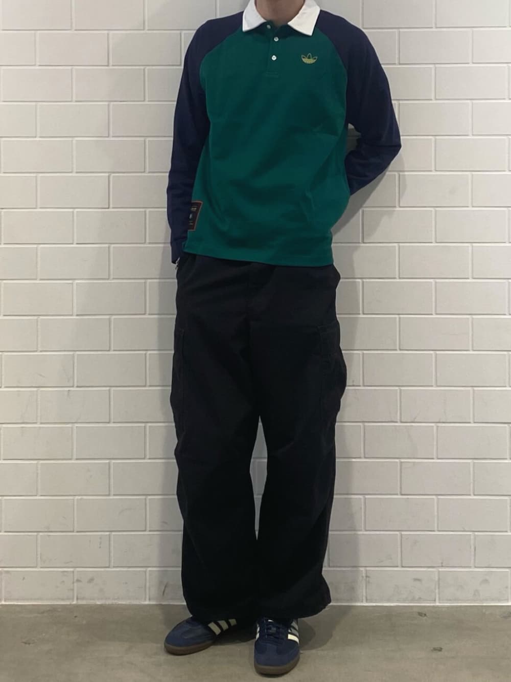 ブルー系のスニーカー、グリーン系のポロシャツを着用したメンズの冬コーディネートの2枚目の写真