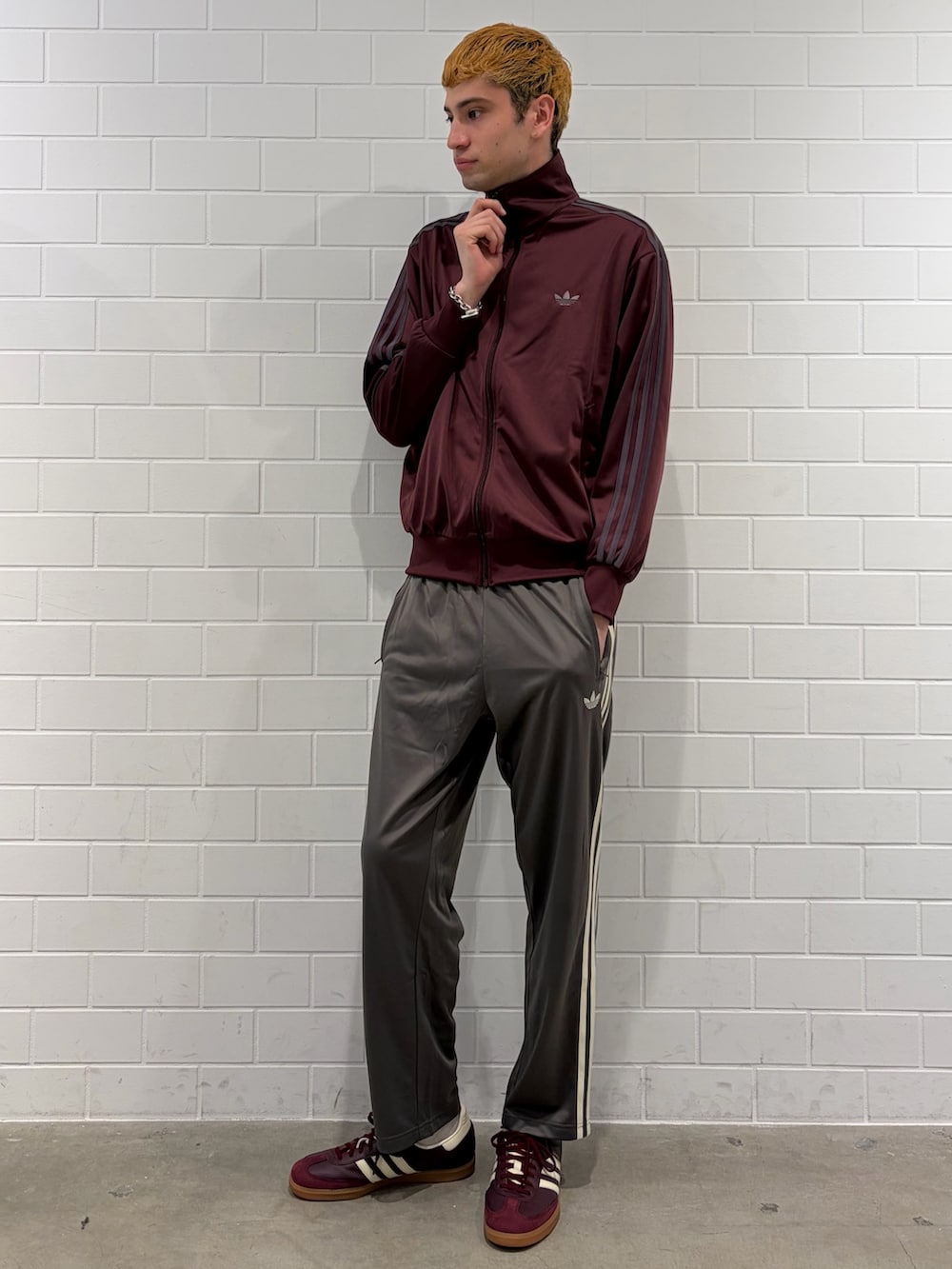 レッド系のスニーカー、レッド系のジャージ、グレー系のその他パンツを着用したメンズの春コーディネートの3枚目の写真