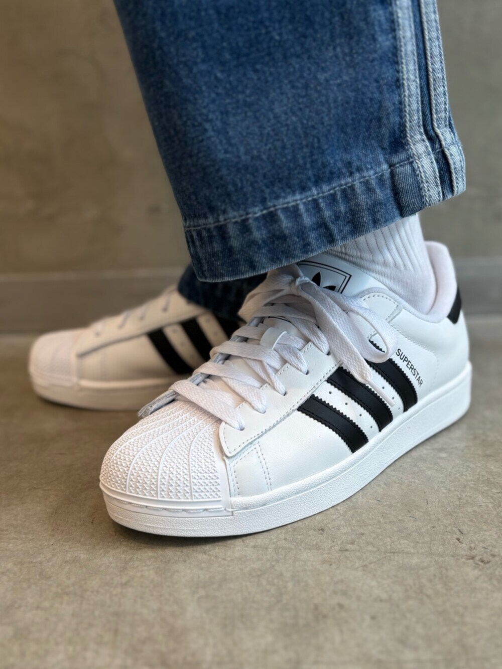 グリーン系のナイロンジャケット、ブルー系のデニムパンツ、ホワイト系のTシャツ/カットソーを着用したメンズの春コーディネートの6枚目の写真