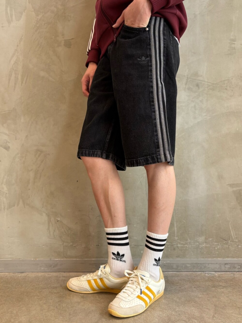 ホワイト系のスニーカー、レッド系のナイロンジャケット、ブラック系のその他パンツを着用したメンズの夏コーディネートの5枚目の写真