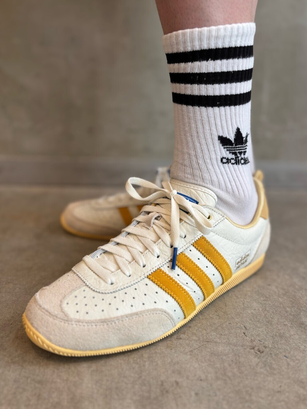 ホワイト系のスニーカー、レッド系のナイロンジャケット、ブラック系のその他パンツを着用したメンズの夏コーディネートの6枚目の写真