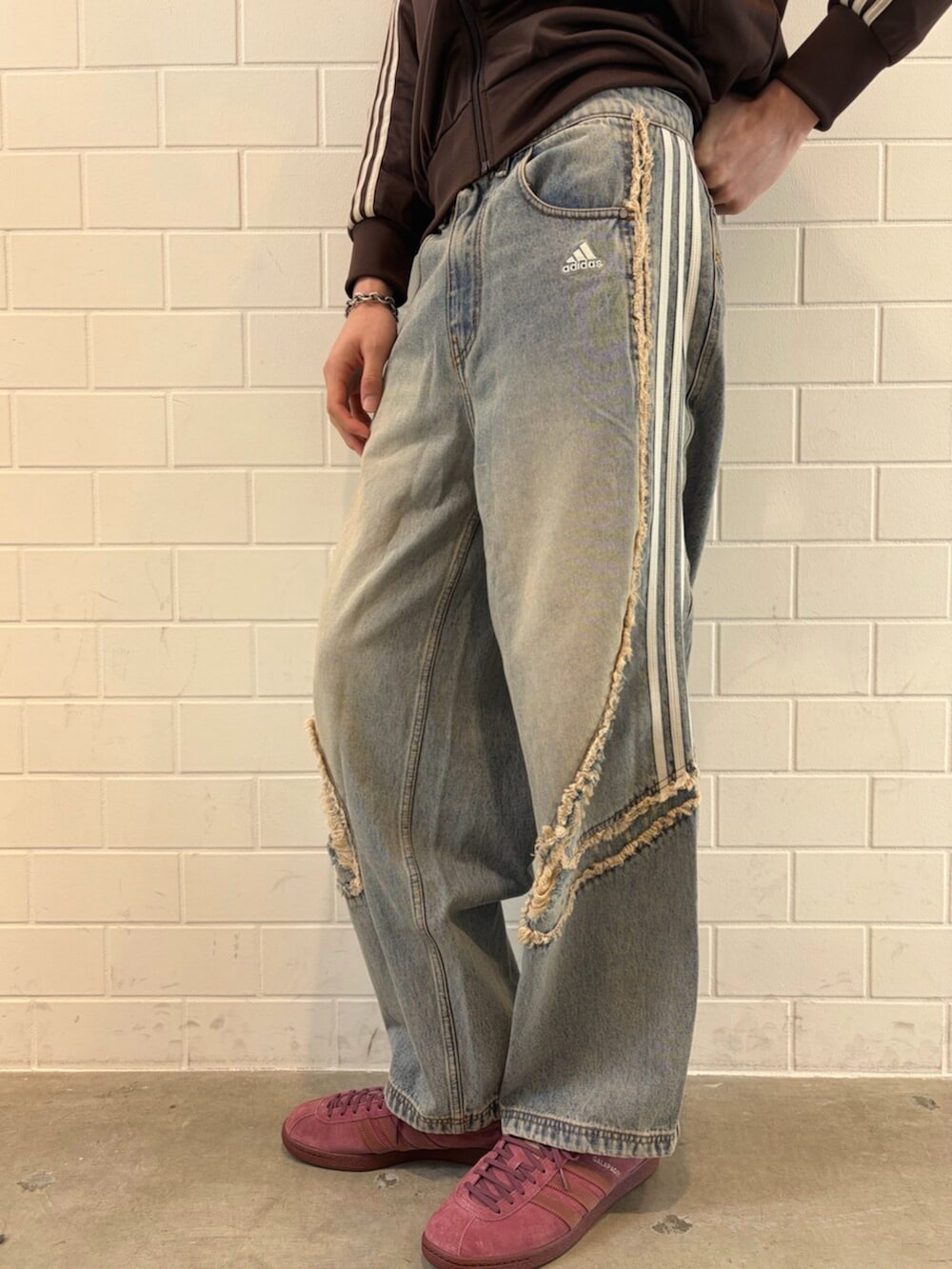 ブルー系のデニムパンツ、ブラウン系のジャージ、レッド系のシューズを着用したメンズの春コーディネートの5枚目の写真