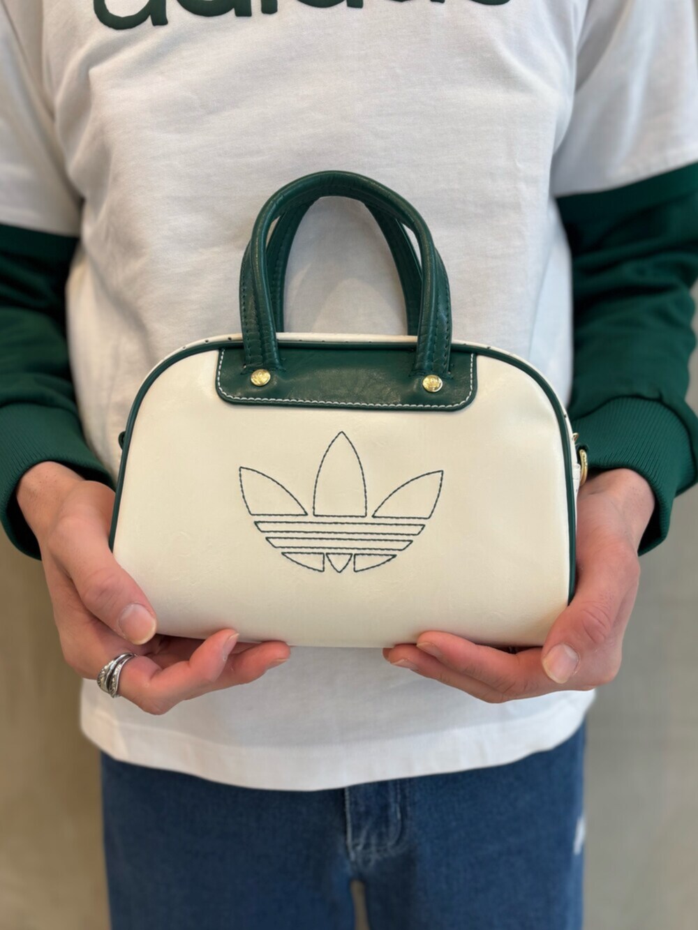 グリーン系のナイロンジャケット、ブルー系のデニムパンツ、ホワイト系のTシャツ/カットソーを着用したメンズの春コーディネートの3枚目の写真