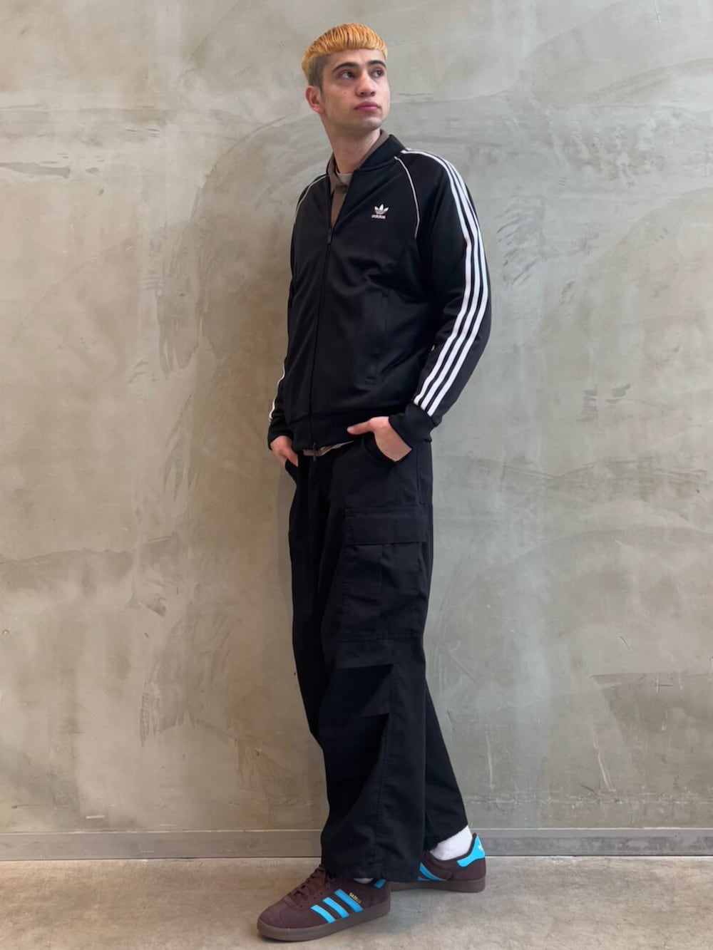 ブラウン系のジャケット/アウター、ブラウン系のスニーカー、ブラック系のジャージを着用したメンズの冬コーディネートの3枚目の写真