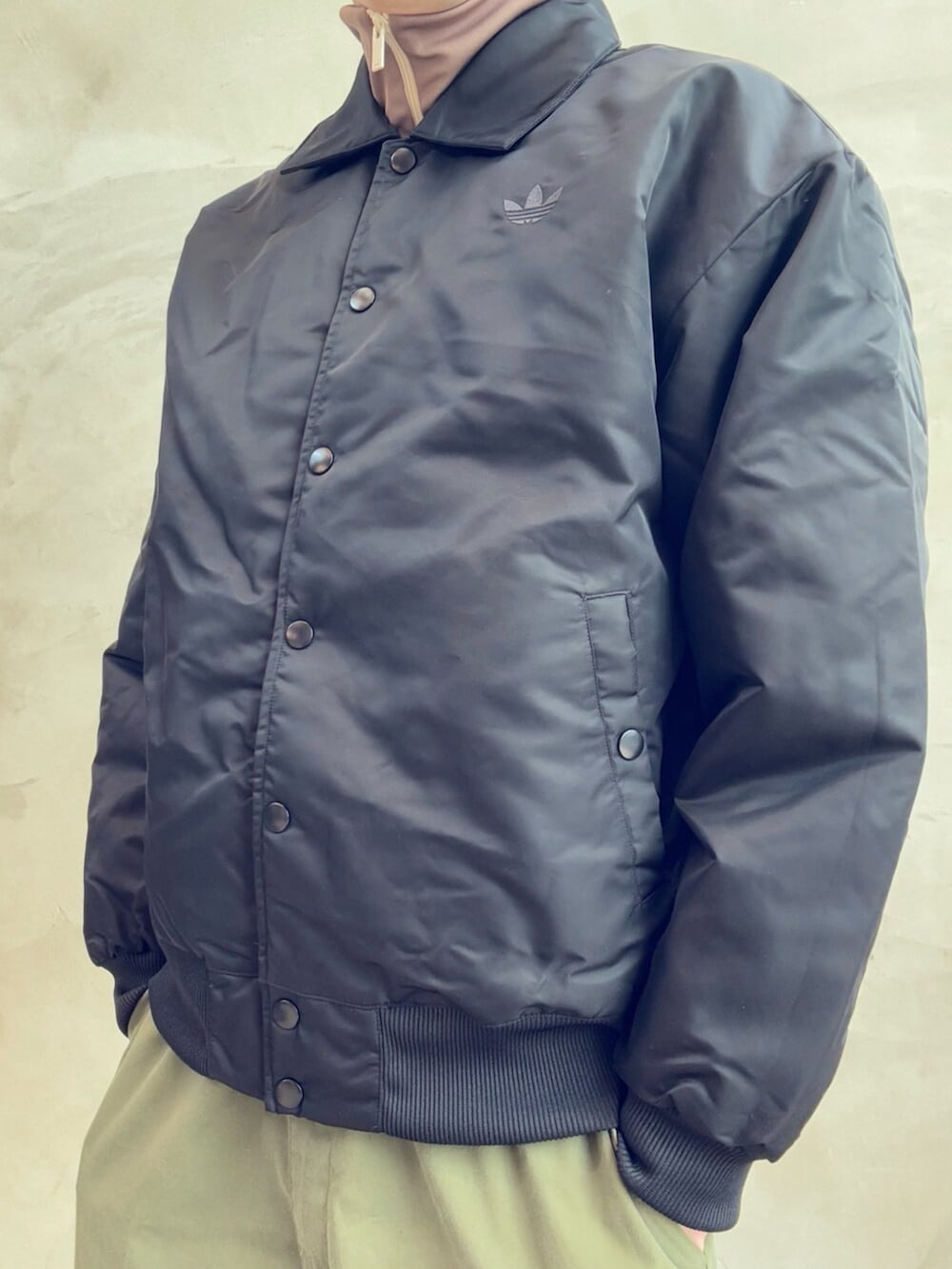 ブラック系のブルゾン、レッド系のスニーカー、ホワイト系のトップスを着用したメンズの春コーディネートの4枚目の写真