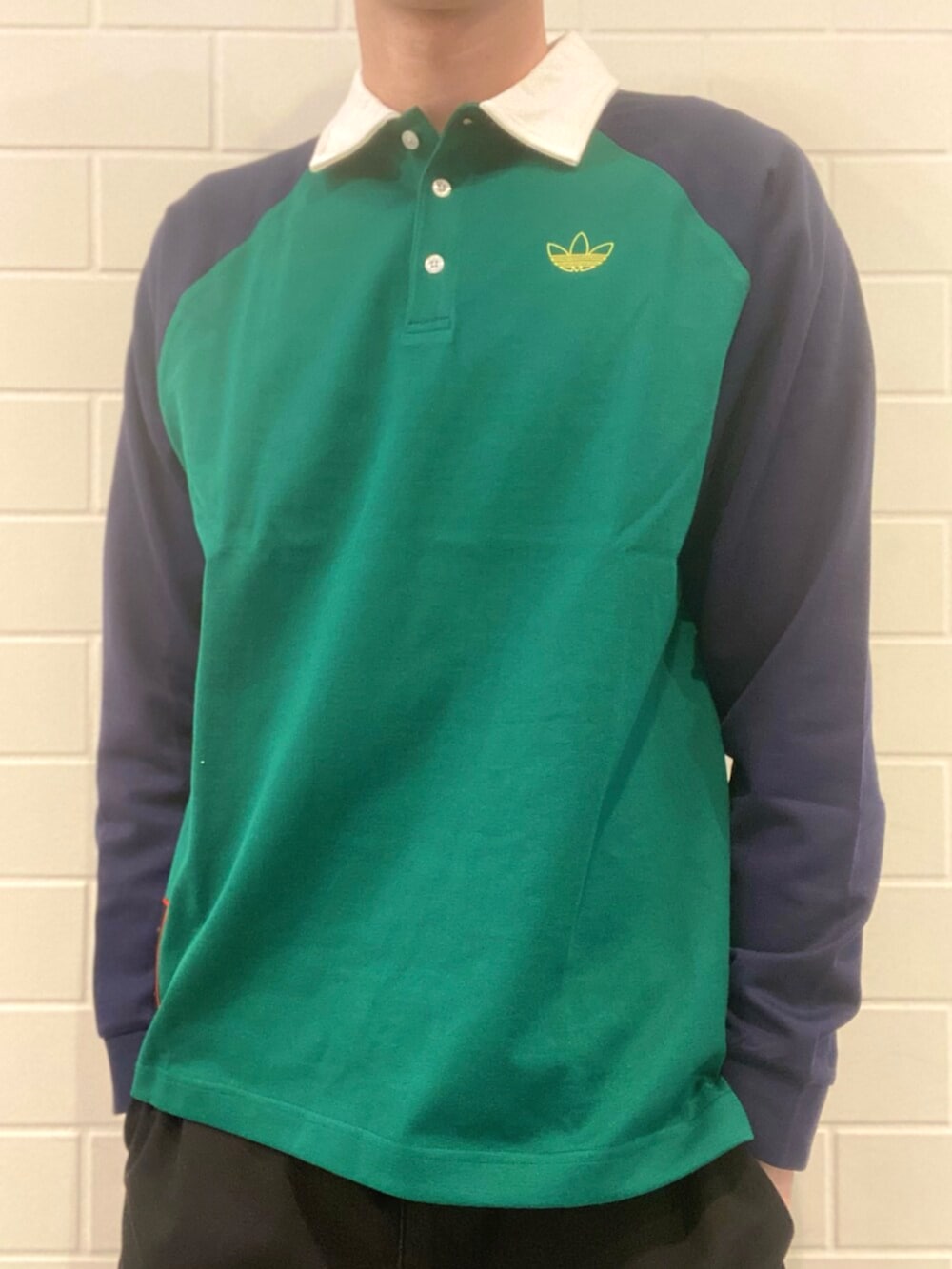 ブルー系のスニーカー、グリーン系のポロシャツを着用したメンズの冬コーディネートの3枚目の写真