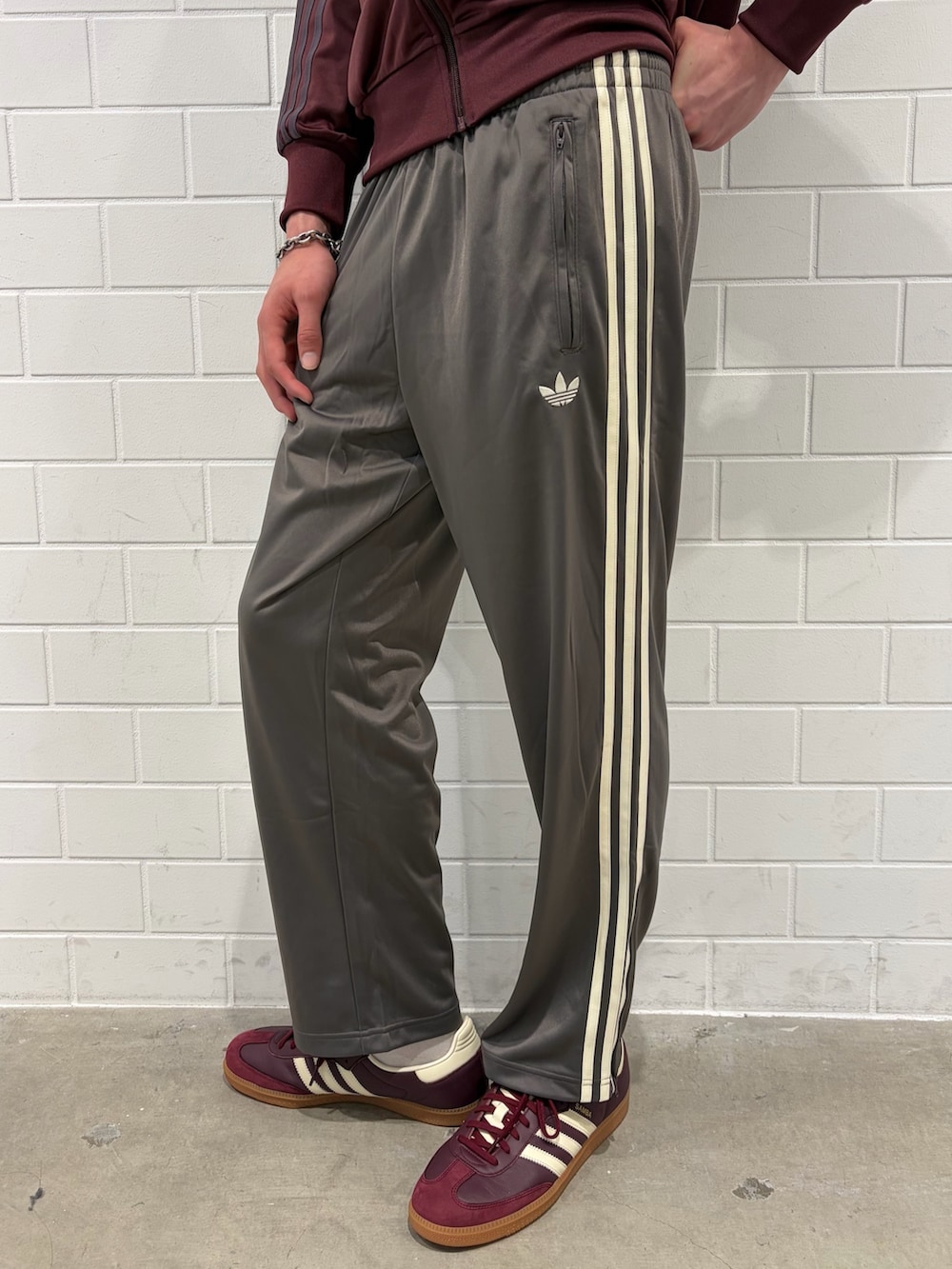 レッド系のスニーカー、レッド系のジャージ、グレー系のその他パンツを着用したメンズの春コーディネートの5枚目の写真