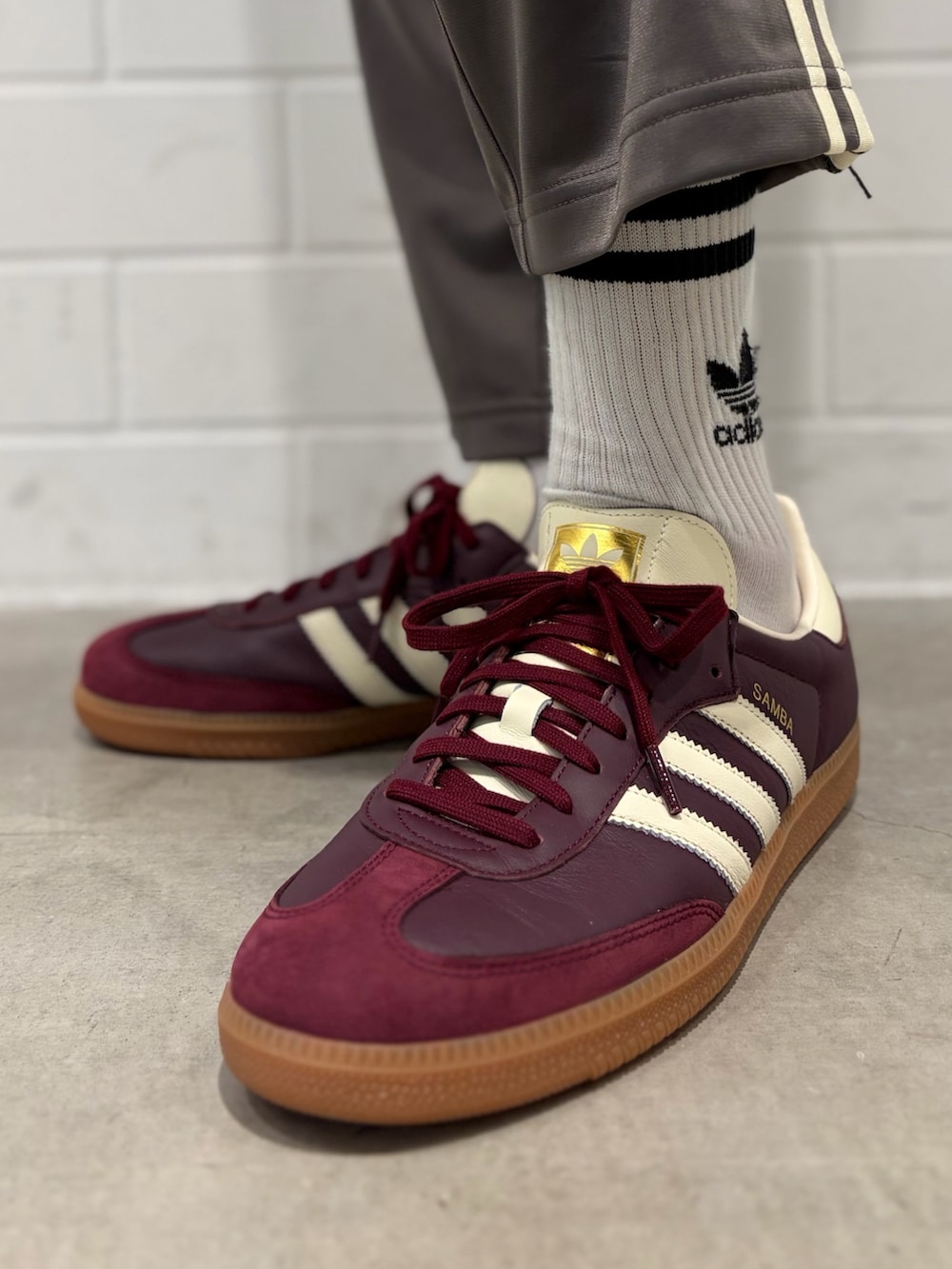 レッド系のスニーカー、レッド系のジャージ、グレー系のその他パンツを着用したメンズの春コーディネートの6枚目の写真