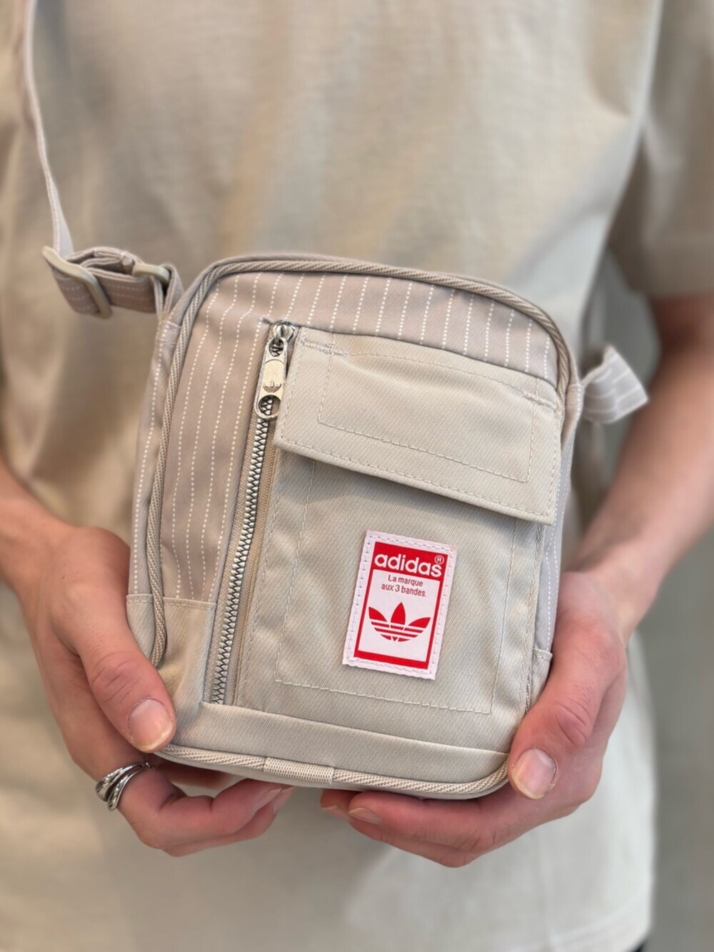 ブルー系のスウェットパンツ、ベージュ系のTシャツ/カットソー、レッド系のスニーカーを着用したメンズの春コーディネートの4枚目の写真