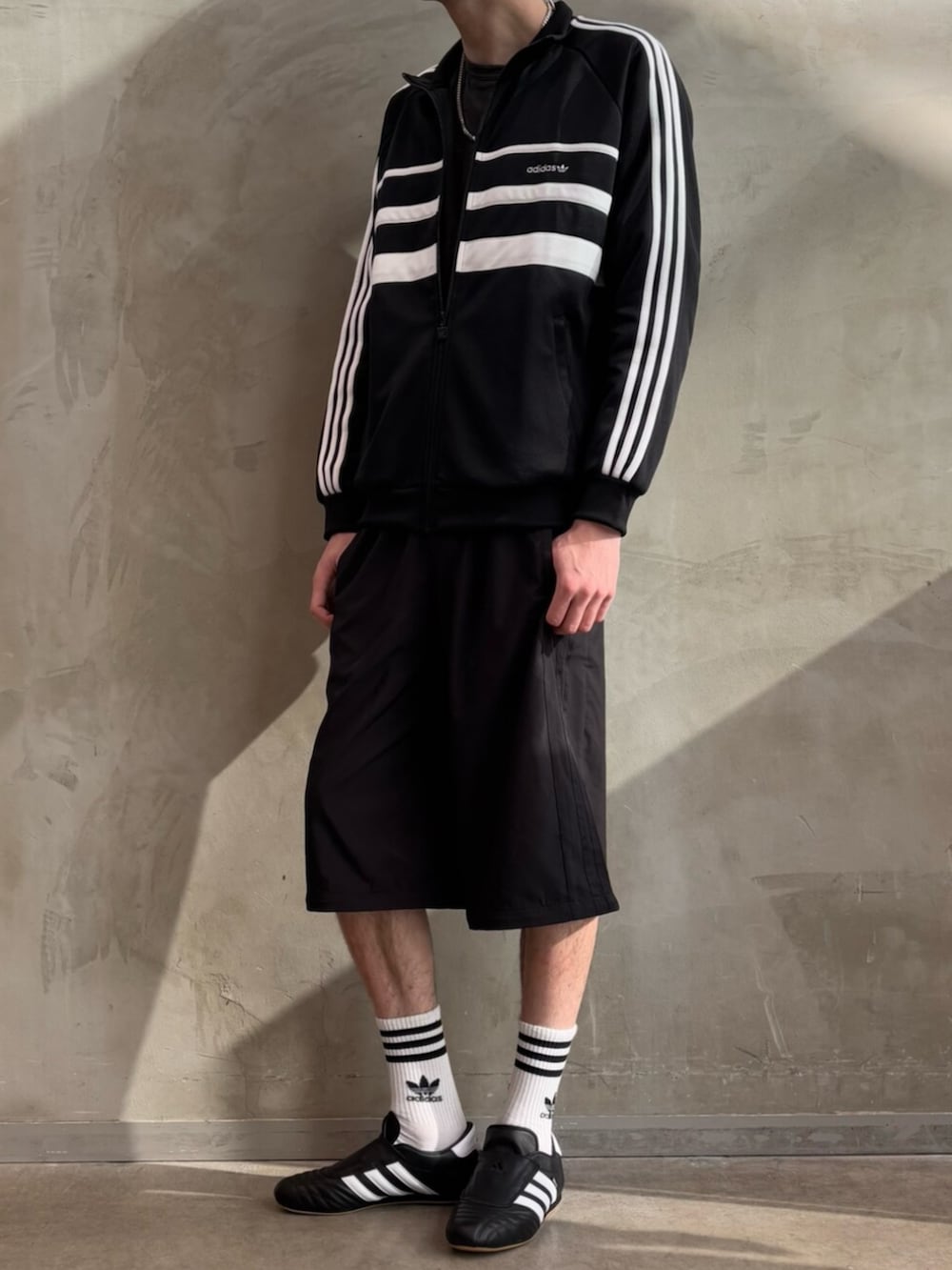 ブラック系のその他パンツ、ブラック系のジャージ、ブラック系のシューズを着用したメンズの冬コーディネートの2枚目の写真