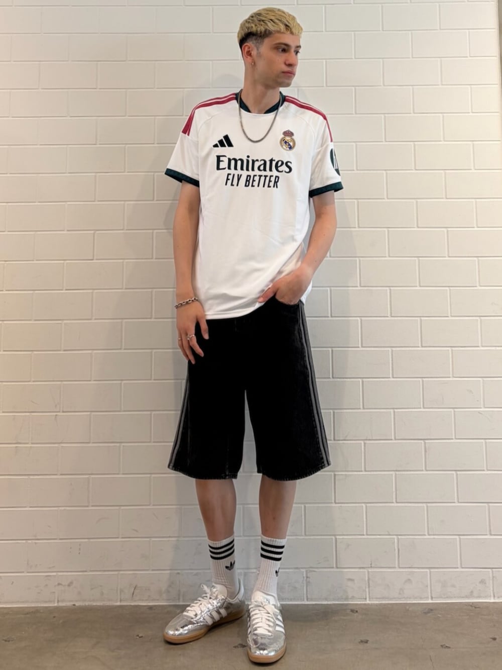 シルバー系のスニーカー、ブラック系のデニムパンツ、ホワイト系のTシャツ/カットソーを着用したメンズの夏コーディネートの3枚目の写真