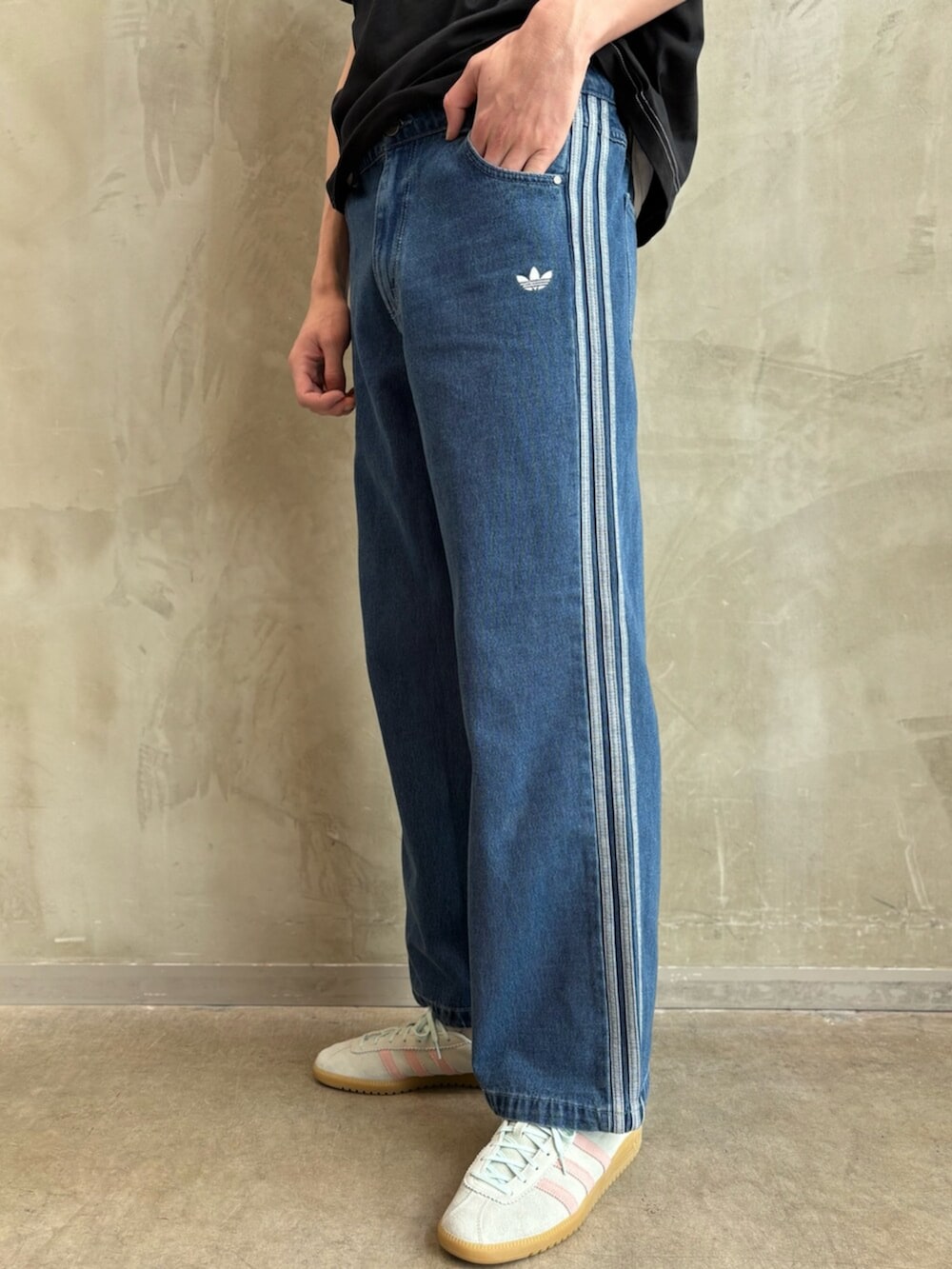 ブルー系のデニムパンツ、グリーン系のスニーカー、ブラック系のTシャツ/カットソーを着用したメンズの春コーディネートの5枚目の写真