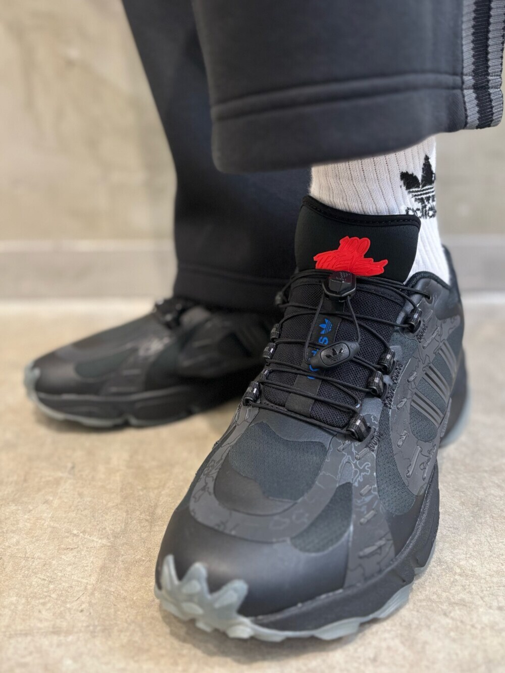 ブラック系のショルダーバッグ、ブラック系のシューズ、ブラック系のナイロンジャケットを着用したメンズの夏コーディネートの6枚目の写真