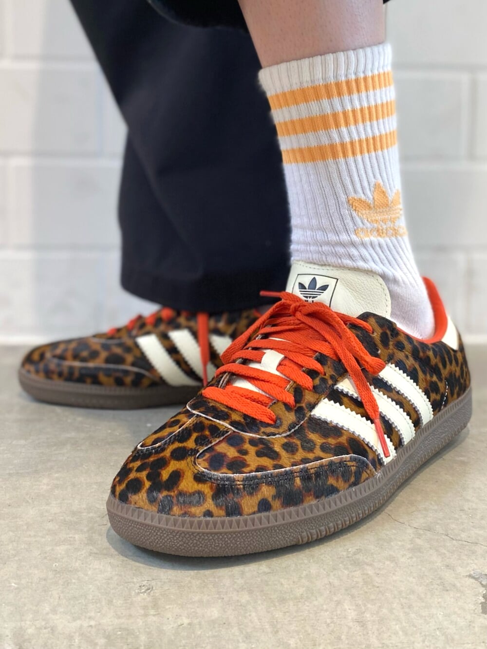 ブラック系のスニーカー、ホワイト系のニット/セーター、ブラック系のデニムジャケットを着用したメンズの秋コーディネートの6枚目の写真