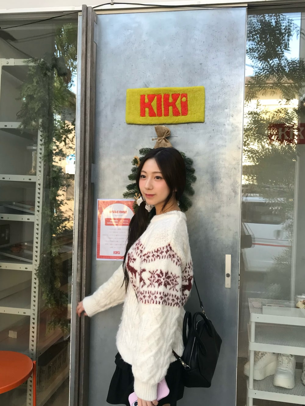 ホワイト系のニット/セーター、ブラック系のスカート、ブラック系のブーツを着用したレディースの冬コーディネートの4枚目の写真