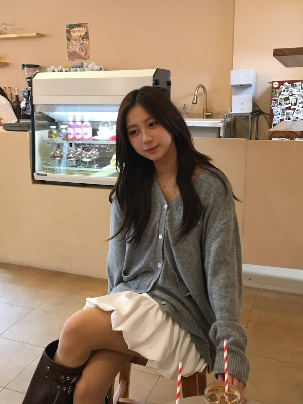 グレー系のカーディガン/ボレロ、ホワイト系のスカート、ブラウン系のブーツを着用したレディースの春コーディネートの4枚目の写真