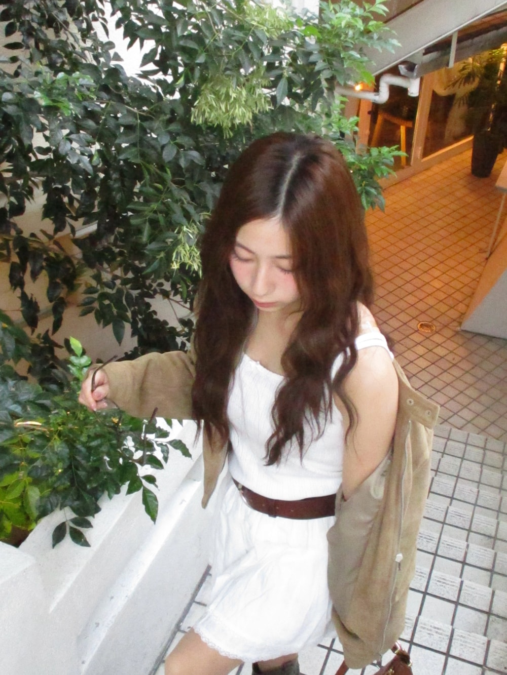 ホワイト系のスカート、ホワイト系のキャミソール、ベージュ系のブルゾンを着用したレディースの秋コーディネートの3枚目の写真