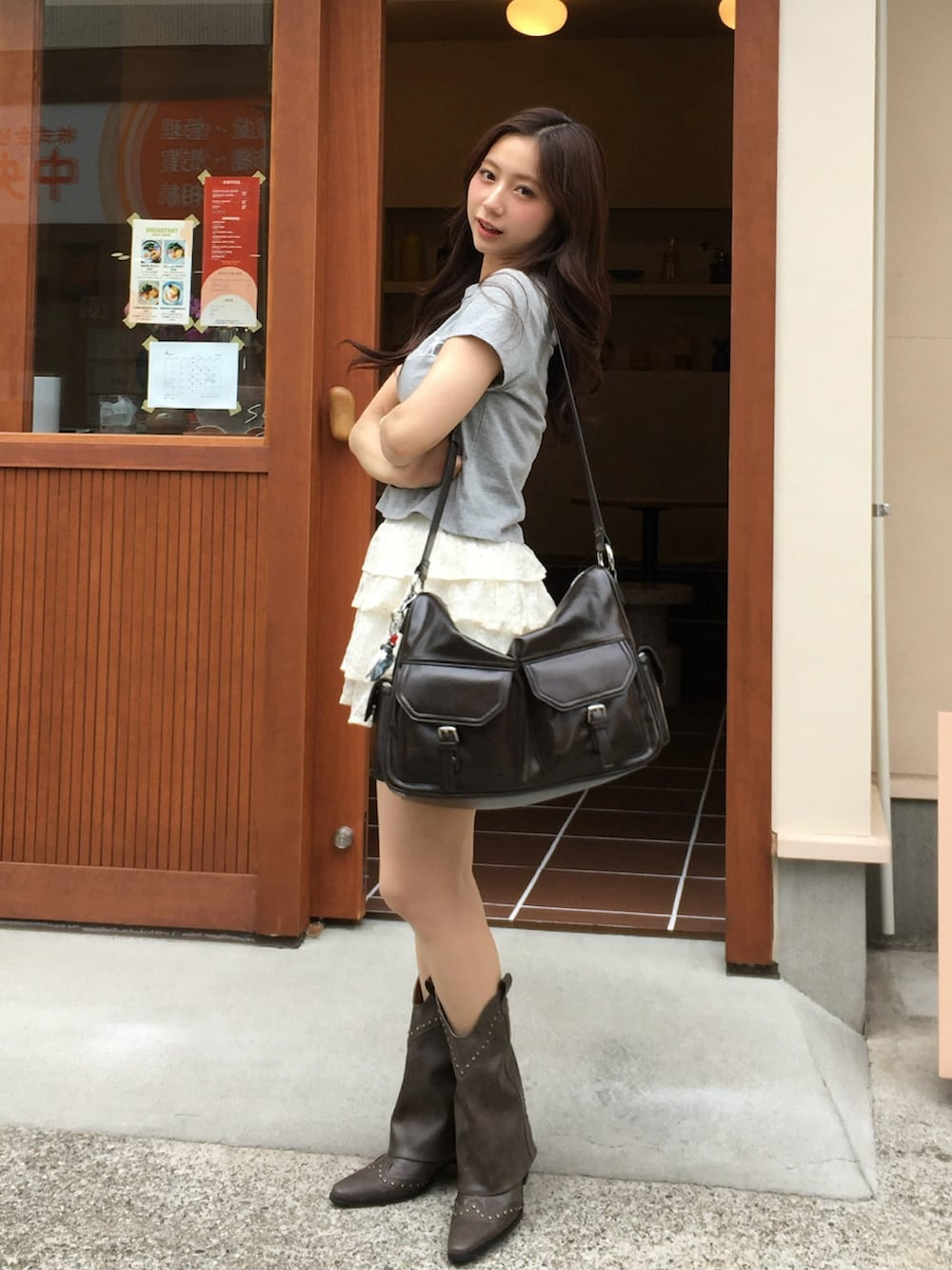 グレー系のTシャツ/カットソー、ホワイト系のスカート、グレー系のブーツを着用したレディースの春コーディネートの2枚目の写真