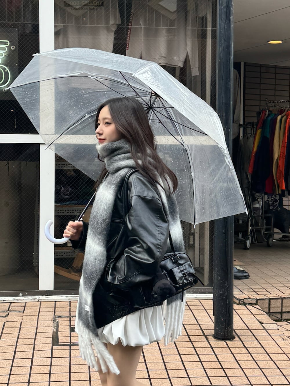 ホワイト系のスカート、ブラック系のブーツ、グレー系のマフラーを着用したレディースの冬コーディネートの3枚目の写真