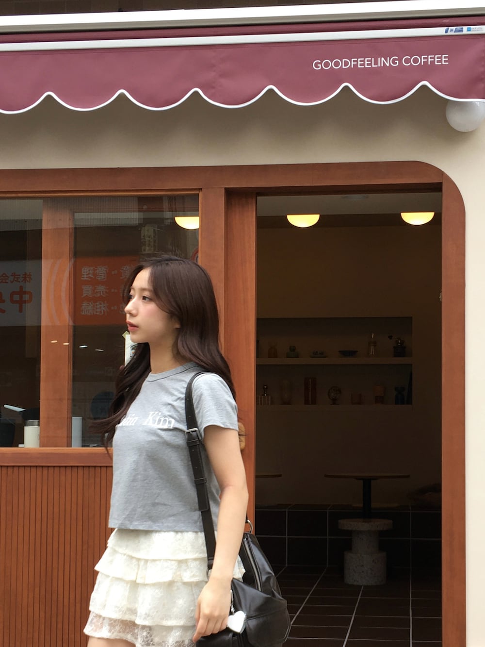 グレー系のTシャツ/カットソー、ホワイト系のスカート、グレー系のブーツを着用したレディースの春コーディネートの3枚目の写真