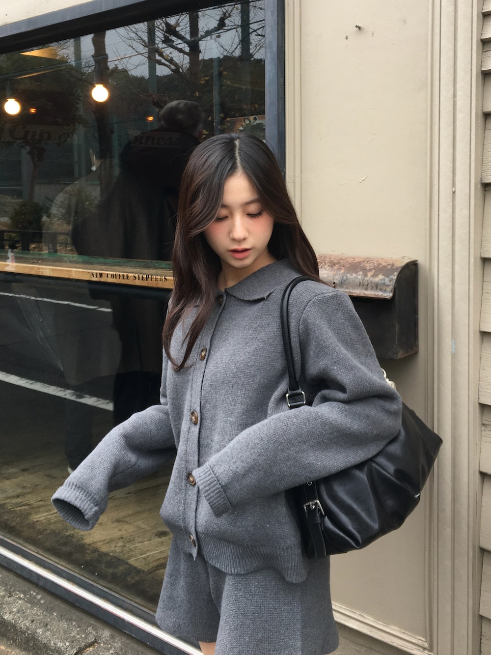 グレー系のニット/セーター、グレー系のその他パンツ、ブラック系のブーツを着用したレディースの冬コーディネートの2枚目の写真