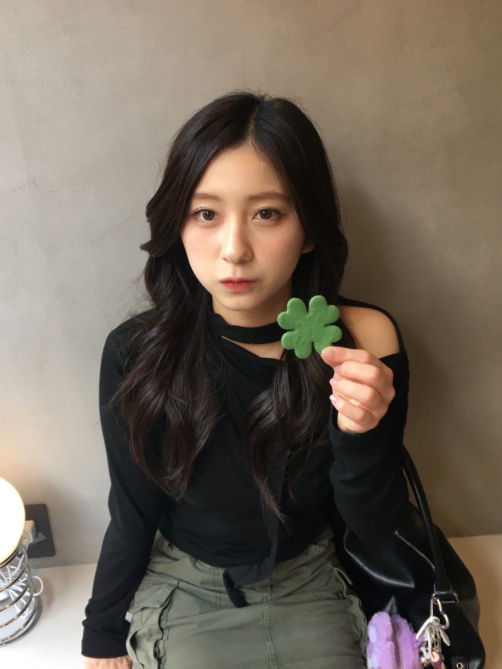 ブラック系のトップス、グリーン系のスカートを着用したレディースの春コーディネートの2枚目の写真