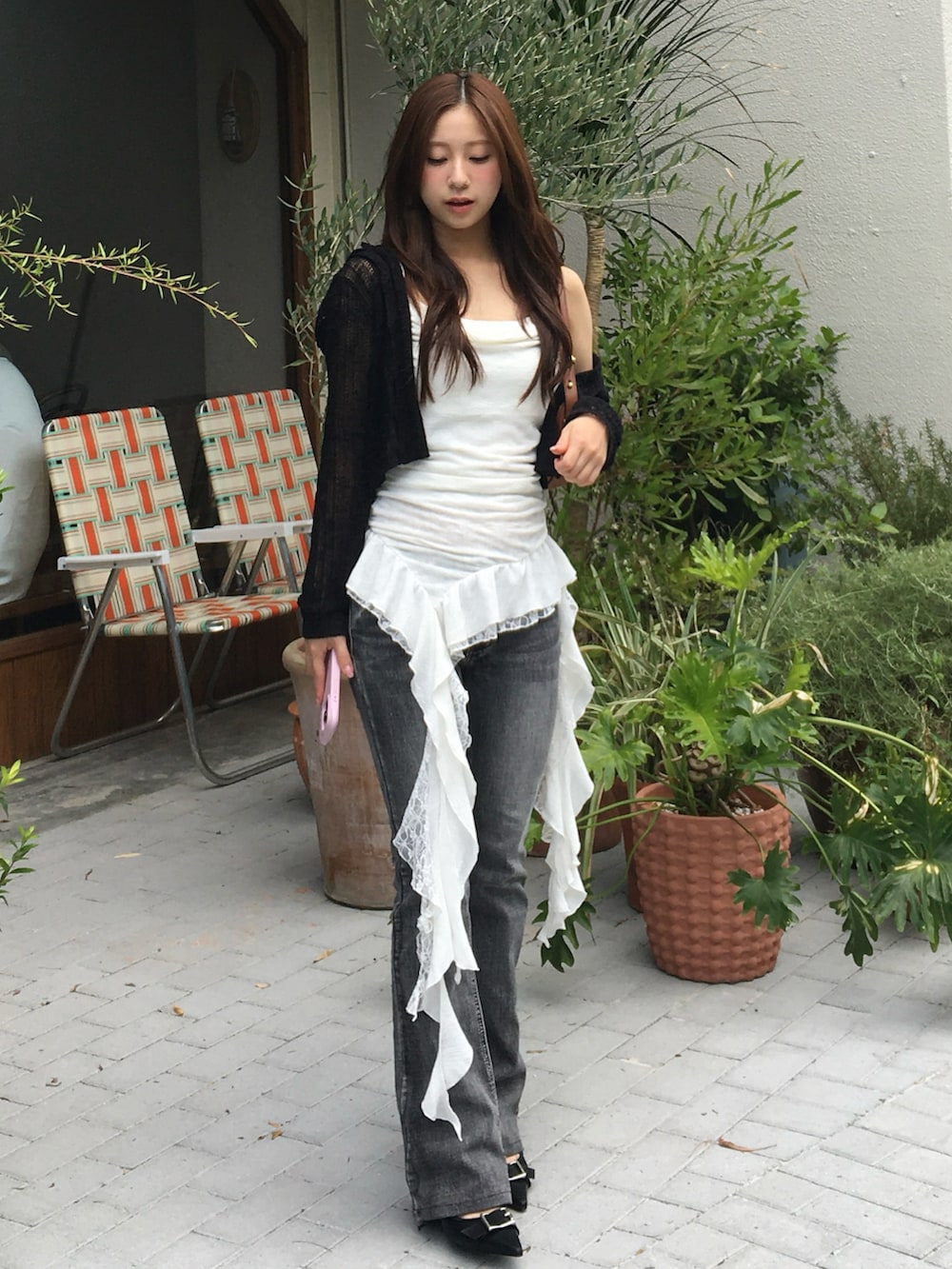 ブラック系のパンプス、ホワイト系のトップス、グレー系のデニムパンツを着用したレディースの夏コーディネートの2枚目の写真