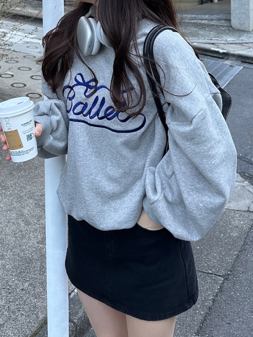 グレー系のスウェット、ブラック系のスカート、ベージュ系のスニーカーを着用したレディースの冬コーディネートの4枚目の写真